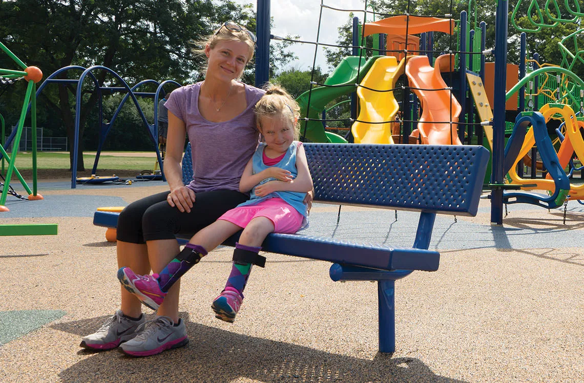 adult and child sitting on a playground bench